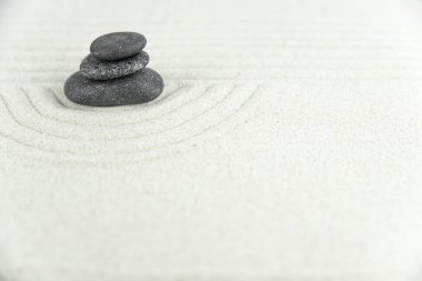 Zen bahçesi. Beyaz ve gri Zen taşlarından piramitler soyut dalga çizimleriyle beyaz kumun üzerinde. Uyum kavramı, denge ve meditasyon, spa, masaj, rahatlama.
