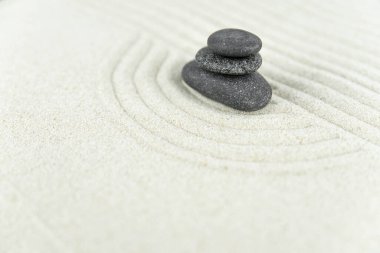 Zen bahçesi. Beyaz ve gri Zen taşlarından piramitler soyut dalga çizimleriyle beyaz kumun üzerinde. Uyum kavramı, denge ve meditasyon, spa, masaj, rahatlama.