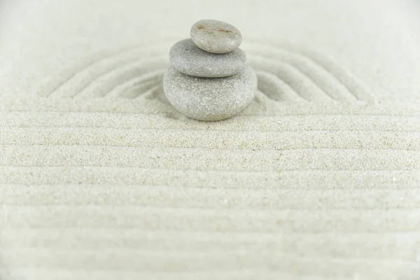 禅の庭 白い砂の上に白と灰色の禅の石のピラミッドの抽象的な波の図面 バランスと瞑想 マッサージ リラックスの概念 — ストック写真