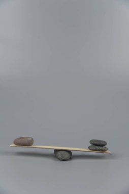 Denge, dengesizlik ve dengesizlik. Tahta tahtadan tahterevallide Zen taşları. Uyum, sakinlik, yoga ve meditasyon, spa, masaj, rahatlama. Zen bahçesi.