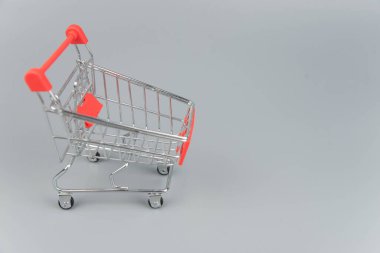 Moda gri arka planda fotokopi alanı olan boş alışveriş arabasının yakın plan görüntüsü 