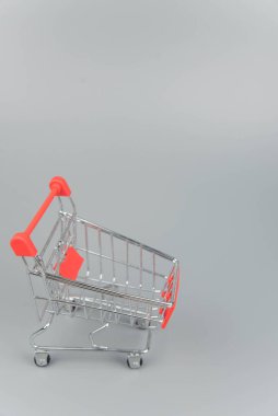 Moda gri arka planda fotokopi alanı olan boş alışveriş arabasının yakın plan görüntüsü 
