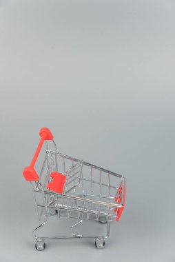 Moda gri arka planda fotokopi alanı olan boş alışveriş arabasının yakın plan görüntüsü 