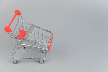 Moda gri arka planda fotokopi alanı olan boş alışveriş arabasının yakın plan görüntüsü 
