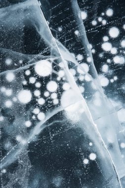Buz dokusu yakın plan. Sibirya 'daki donmuş Baykal Gölü. Hava ve metan baloncukları ile güzel kırılmış buz. 