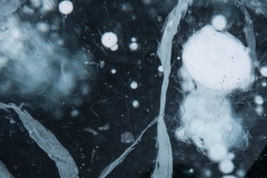 Buz dokusu yakın plan. Sibirya 'daki donmuş Baykal Gölü. Hava ve metan baloncukları ile güzel kırılmış buz. 