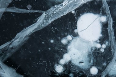 Buz dokusu yakın plan. Sibirya 'daki donmuş Baykal Gölü. Hava ve metan baloncukları ile güzel kırılmış buz. 