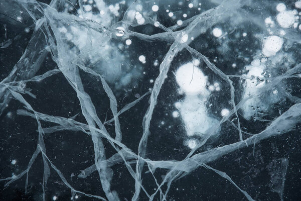 Ice texture close-up. Frozen Baikal lake in Siberia. Beautiful cracked ice with air and methane bubbles. 