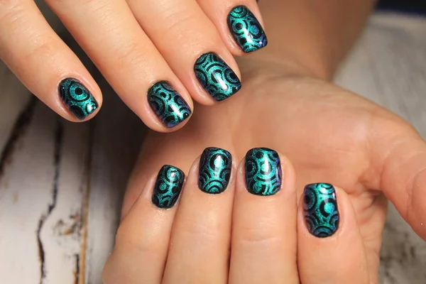 fashionable green manicure on a beautiful textural background