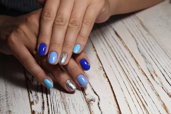 fashionable blue manicure of nails on a beautiful textural background