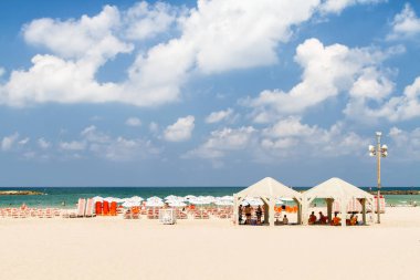 Tel Aviv, İsrail - 09 Ağustos 2018: Deniz Akdeniz, plaj şemsiye ve şezlonglar, Tel Aviv, İsrail bulutlu gökyüzü mavi