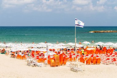 Tel Aviv, İsrail - 09 Ağustos 2018: Deniz Akdeniz, plaj şemsiye ve şezlonglar, Tel Aviv, İsrail bulutlu gökyüzü mavi