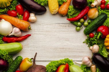 Parlak ahşap arka planda taze organik sebze çerçevesi. Üst görünüm.