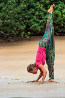 Pratik Yoga sahilde genç çekici kadın. Açık havada yoga. Doğada egzersizleri.