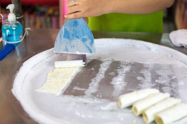 Kızarmış dondurma yapma süreci. Dondurulmuş tavada Tayland usulü kızarmış dondurma. Organik, doğal sarılmış dondurma, el yapımı tatlı. Çelik soğutmalı kızarmış dondurma makinesi..