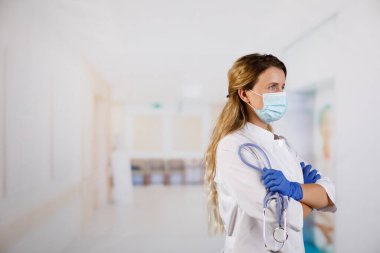 Kolları çapraz duran, tıbbi maske takan kendine güvenen kadın doktor. kadın portresi.