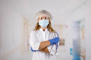 Kolları çapraz duran, tıbbi maske takan kendine güvenen kadın doktor. kadın portresi.