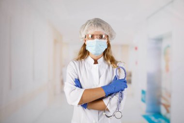 Kolları çapraz duran, tıbbi maske takan kendine güvenen kadın doktor. kadın portresi.