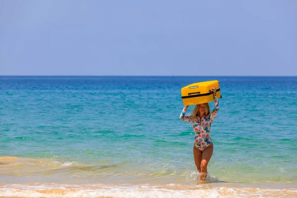 Όμορφο Κορίτσι Μαγιό Στην Παραλία Κίτρινη Βαλίτσα Μπλε Θάλασσα Κίτρινη — Φωτογραφία Αρχείου