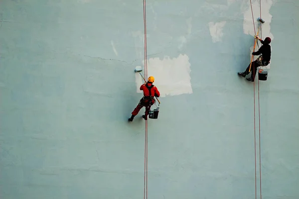 産業の登山者が建物の壁を塗る — ストック写真