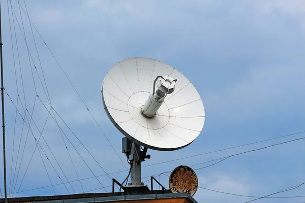 large iron satellite dish and a small rusty