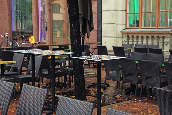 tables and chairs in a street cafe after rain in autumn