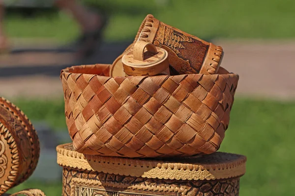 carved wooden handmade dishes in a wicker basket