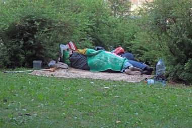 çimenlerin üzerinde uyuyan evsiz insanlar