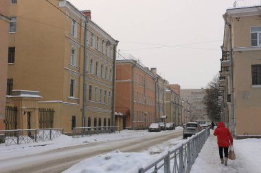 bir kadın bir şehir bir kar fırtınası sırasında sokak aşağı yürüyüş kırmızı ceket