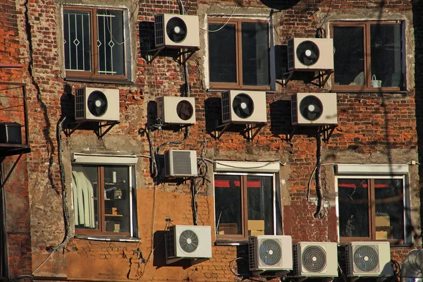 air conditioners on the wall of an old brick building