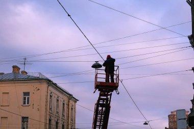 Adam platformunda gökyüzüne karşı yüksek fener onarır