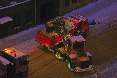 Traktör sokağın ortasında büyük kamyon kar yükler
