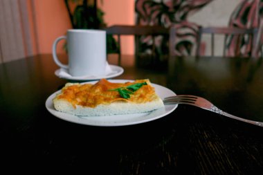 bir fincan çay yemek odasında kahvaltı ile masaya bir tabak yumurta omlet