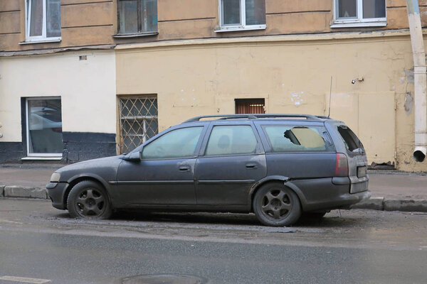 the car is parked in the street with a broken rear window