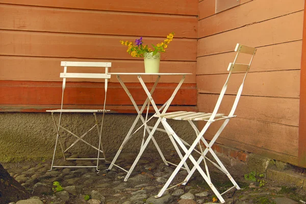 white table and outdoor chairs in an outdoor cafe