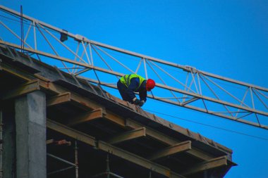 Bir kule vinç patlaması altında bir şantiyede bir kask işçi