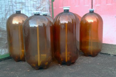 bahçede büyük boş otuz litre plastik kahverengi bira şişeleri