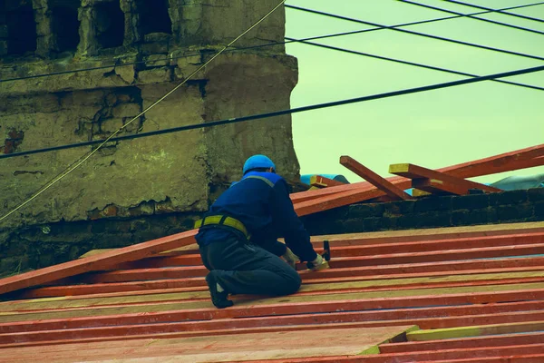 一个穿着工作服的男人在屋顶上做修理工作 — 图库照片