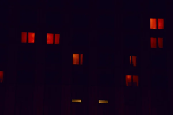 Glowing apartment windows at night where each occupant has his own privacy