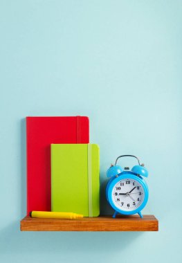 Not defteri ve raf duvar arka plan yüzeyi, çalar saat