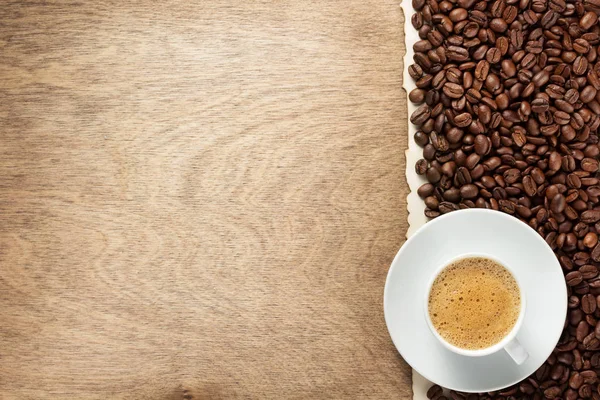 コーヒー豆と木製の背景 上面のソーサーとカップ — ストック写真