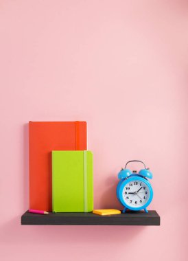 Not defteri ve raf duvar arka plan yüzeyi, çalar saat