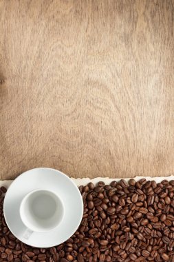 kahve çekirdekleri ve Kupası ahşap arka plan, üstten görünüm üzerinde uçan daire ile