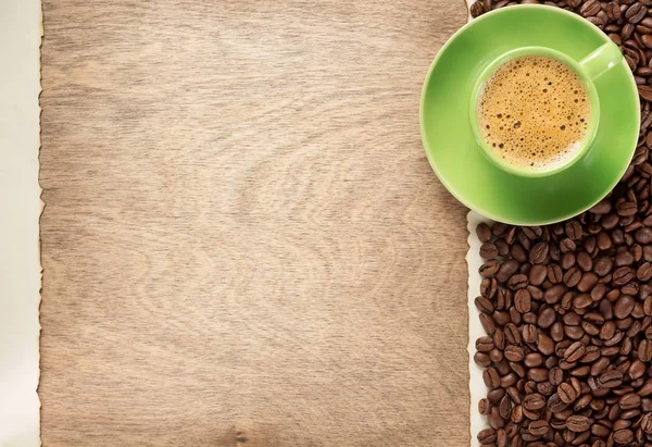 kahve çekirdekleri ve Kupası ahşap arka plan, üstten görünüm üzerinde uçan daire ile