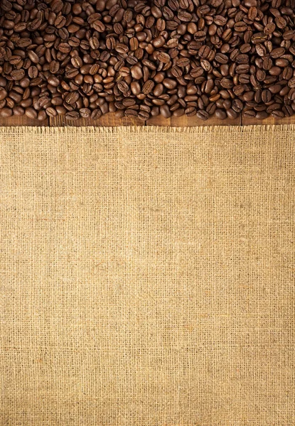木製の背景 トップ ビューで袋 Hessian 黄麻布背景でコーヒー豆 — ストック写真