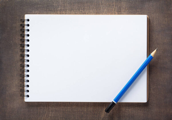 notepad at wooden background surface table, top view