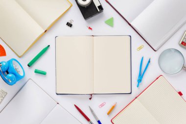 Okul aksesuarları ve defter veya boş sayfaları kitap beyaz arka planda, üstten görünüm