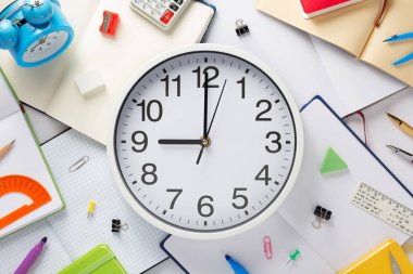 Okul aksesuarları ve duvar saati Not defteri veya kitap ile boş sayfa, üstten görünüm