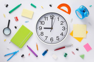 Okul aksesuarları ve duvar saati, beyaz arka plan, üstten görünüm