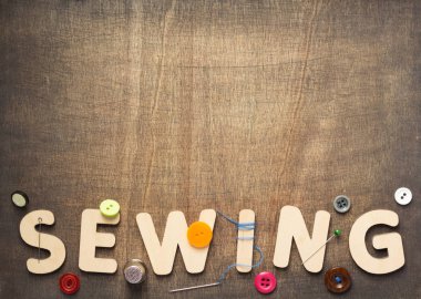 Dikiş Araçları ve harfler üzerinde ahşap masa arka plan, üstten görünüm